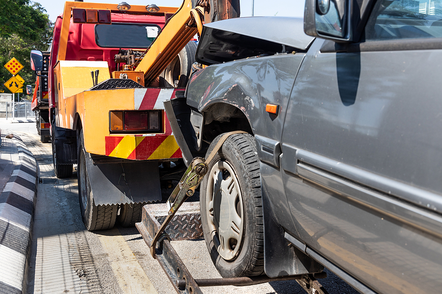 Tow truck towing a broken down car in emergency on the street